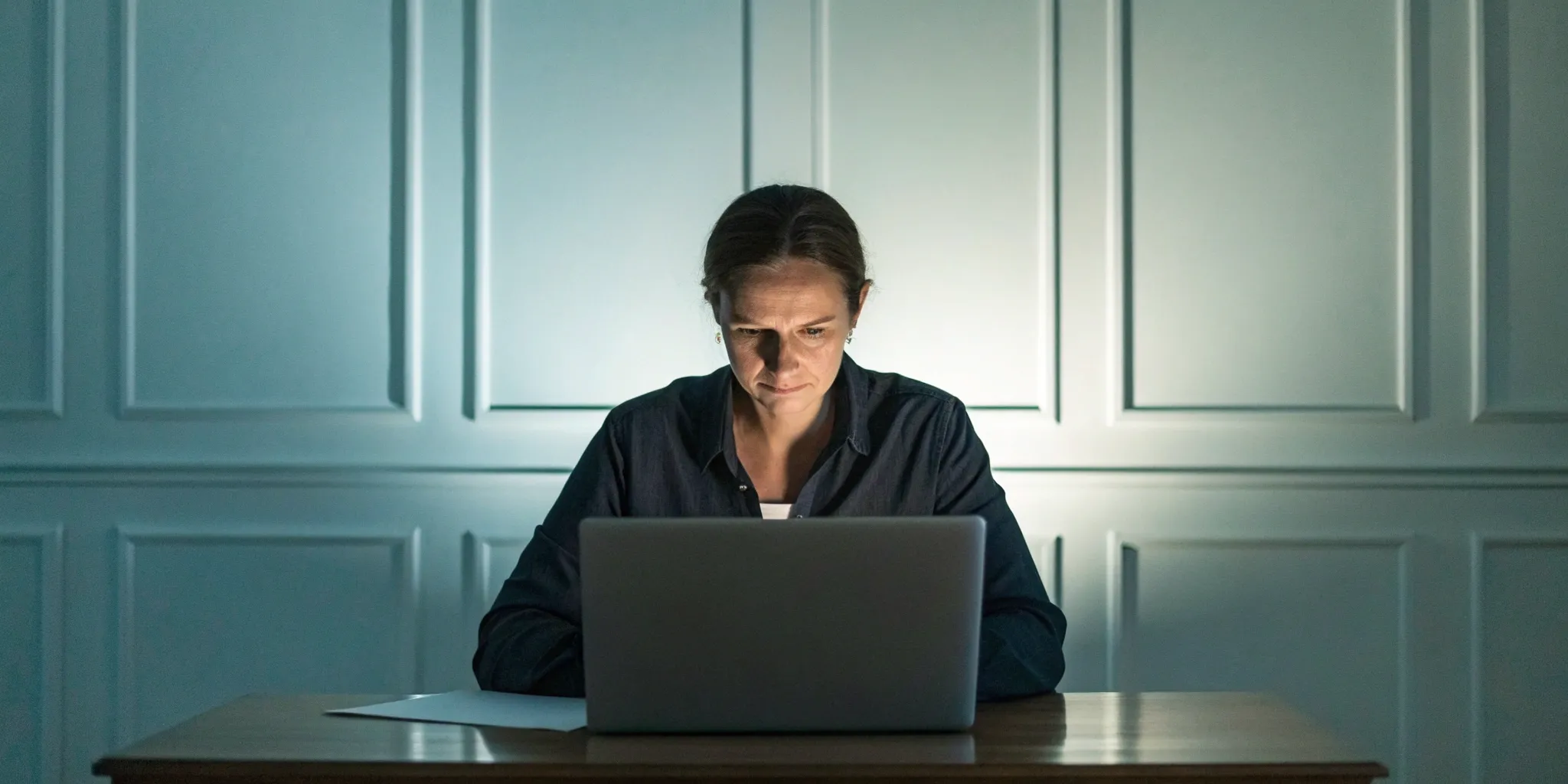 Woman focused on a laptop, filing an Experian dispute online.